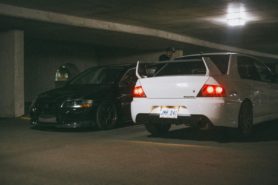 Two Mitsubishi Lancer Evos parked next to each other in a car park