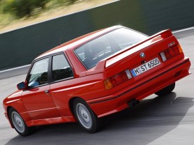 Red M3 Coupe driving down the road