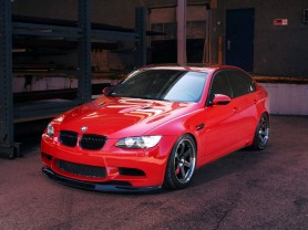 Red BMW M3 Sedan parked on a dark evening