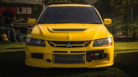 Yellow Mitsubishi Lancer Evo parked on the grass